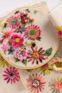 two embroidered hoops with colorful flowers on them