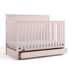 a pink crib with white sheets on the bottom and side rails, in front of a white background