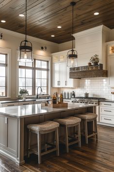 a large kitchen with white cabinets and wooden flooring on the ceiling, along with stools in front of an island