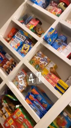 a white shelf filled with lots of different types of snacks and candy bar wrappers