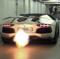 a white sports car driving through a garage