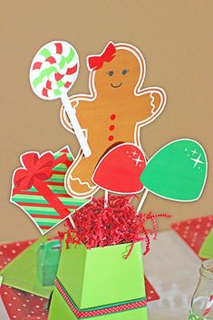 a gingerbread man centerpiece on top of a green box with candy canes