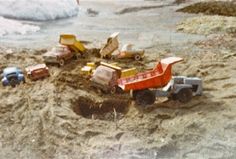 there are many toy trucks in the sand