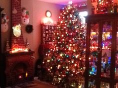 a living room with a christmas tree in the corner and other decorations on the wall