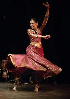 a woman in a red and gold dress is dancing