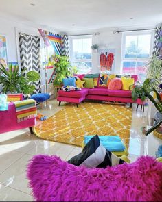 a brightly colored living room filled with lots of furniture and decor on top of a white tiled floor