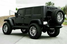 a black jeep is parked in a parking lot