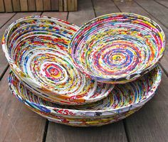 three bowls made out of magazines sitting on top of a wooden table next to each other