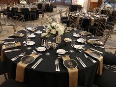 a black table with white and gold place settings