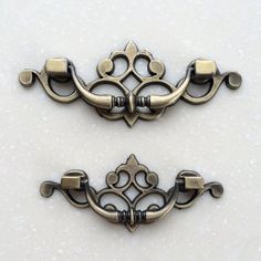 two antique style handles on a white surface