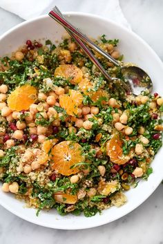 a salad with oranges and chickpeas in a white bowl on a table