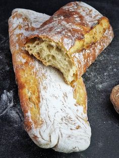 a piece of bread that has been cut in half and is sitting on a black surface