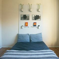 a bed sitting in a bedroom next to a wall with pictures hanging on it's side