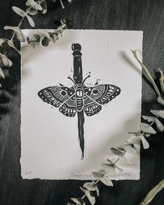 a drawing of a butterfly with a knife in it's center on a piece of paper