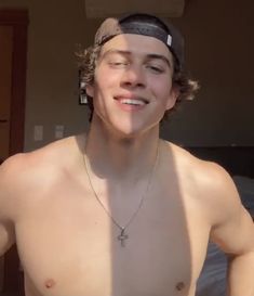 a shirtless young man wearing a cross necklace