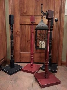 three wooden candlesticks sitting on top of red mats in front of a door