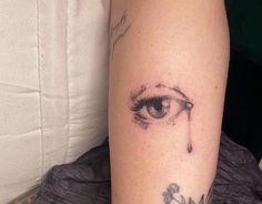 a person with a tattoo on their arm has an eye and the word evil written in it