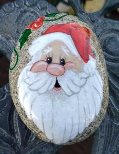 a painted rock with a santa clause on it