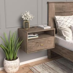 a bedroom with a bed, nightstand and plant in the corner on the side table