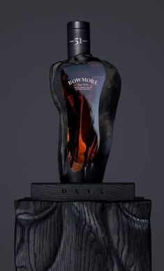 a bottle of perfume sitting on top of a piece of wood with an image of a man's torso