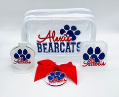 three items are shown in this image with a red bow on the front and blue paw prints on the back