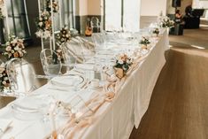 a long table is set up with clear chairs and white linens for an elegant wedding reception