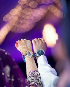 someone is holding their hand up in the air with lights behind them and blurry background