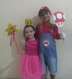 two children dressed up as mario and princess peach the pooh, standing next to each other