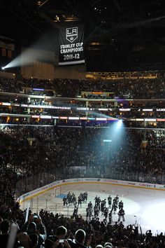 an ice hockey game in progress with the crowd looking on from the sidelines at night