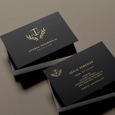 two black and gold business cards on top of each other with the letter l in gold