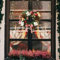 a christmas wreath is hanging on the window sill