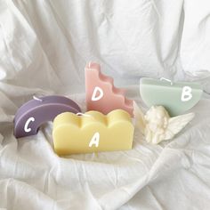 three soap bars sitting on top of a white sheet next to each other with letters carved into them