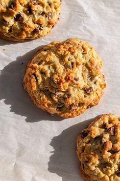 three cookies sitting on top of a piece of parchment paper next to each other,