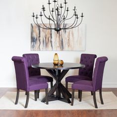 a dining room table with purple chairs and a chandelier