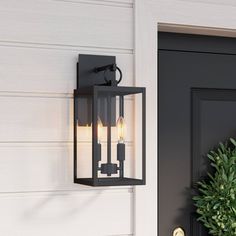 an outdoor light on the side of a house next to a potted plant and door