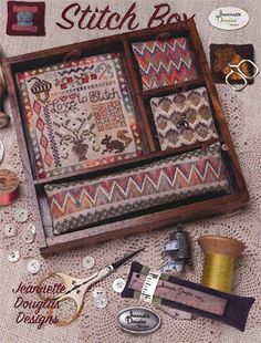 the cover of stitch box, with sewing supplies and thread spools on it