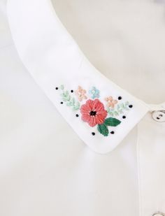 a white shirt with flowers on it and a tie that is tied to the collar