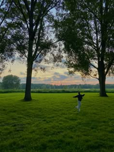 a person standing in the grass with their arms outstretched