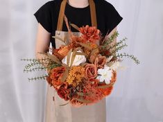 a woman wearing an apron holding a bouquet of flowers