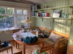 a dining room table and chairs with bookshelves on the wall in front of them