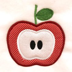 an apple applique with a green leaf on it's tip and eyes