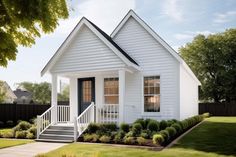 a small white house with black shutters on the front porch and steps leading up to it