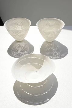 three white bowls sitting on top of a table