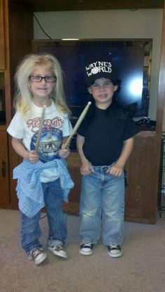 two young children standing next to each other in front of a tv holding baseball bats