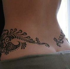 a woman's stomach with a tattoo design on the side of her body,