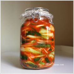 a jar filled with lots of different types of veggies inside of it on a table