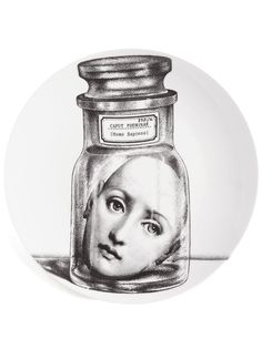 a plate with a drawing of a woman's face in a jar