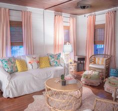 a living room filled with lots of furniture and pillows on top of it's wooden floors