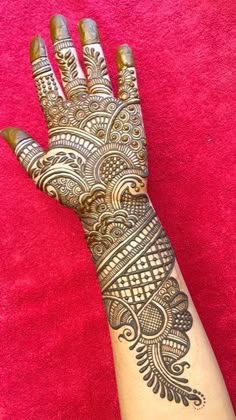 a woman's hand with henna tattoos on it