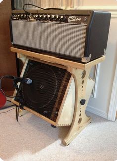 an amp stands next to a red guitar